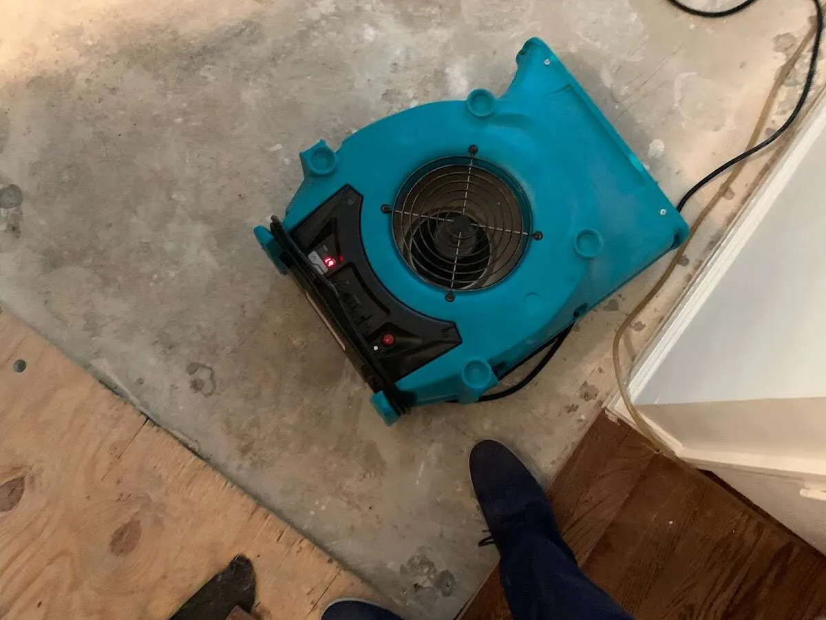 Air mover drying subfloor during Commercial Water Damage Restoration in Delanco